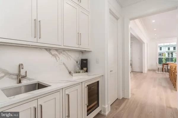 a kitchen with white cabinets and sink