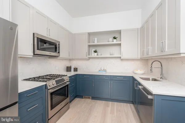 a kitchen with stainless steel appliances a stove sink microwave and cabinets