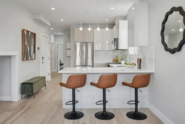 a kitchen with stainless steel appliances granite countertop a table and chairs in it