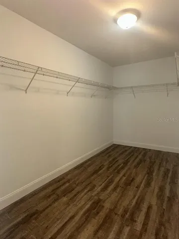 a view of a room with wooden floor and fan