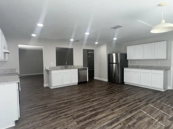 a view of a kitchen with a sink and dishwasher a refrigerator with wooden floor