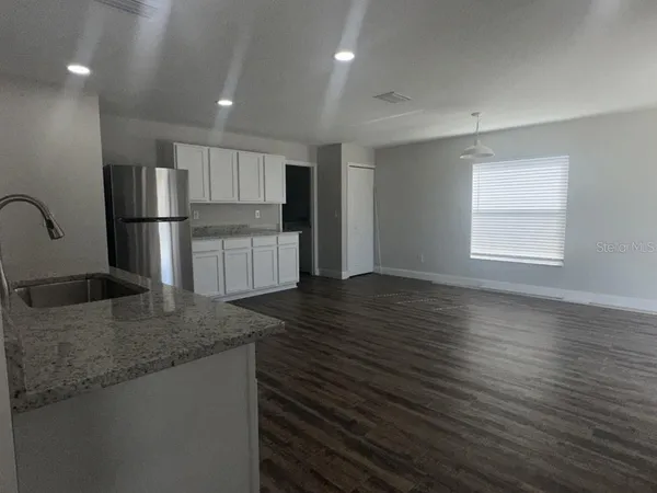 a kitchen with stainless steel appliances granite countertop a sink refrigerator and microwave