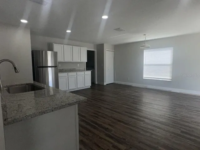 a kitchen with stainless steel appliances granite countertop a sink refrigerator and microwave