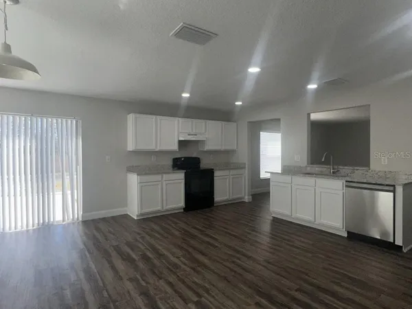 a kitchen with a white cabinets and window