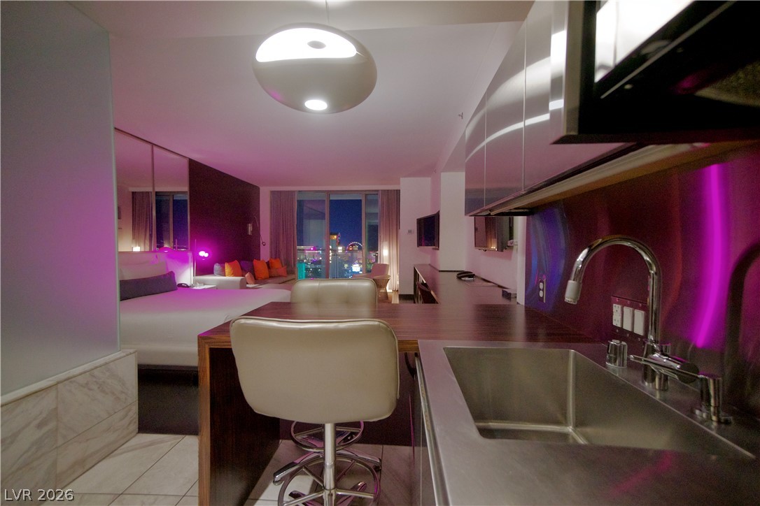 4381 West Flamingo Road, Unit 3616 Las Vegas, NV 89103 - Photo 14 of 29 City lights twinkle beyond this contemporary living space with sleek kitchen amenities and a vibrant ambiance.