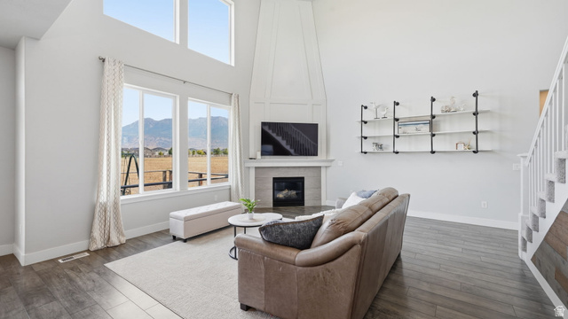 111 East Silver Oak Road Vineyard, UT 84059 - Photo 25 of 50 Spacious living area featuring a vaulted ceiling, large windows, wood-finish flooring, a contemporary fireplace with mantel, and built-in shelving