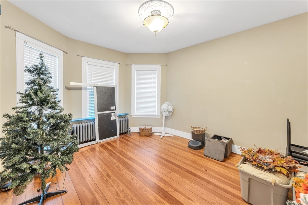 15 Bynner Street, Unit 1 Boston, MA 02130 - Photo 16 of 27 a bedroom with a bed and a chandelier