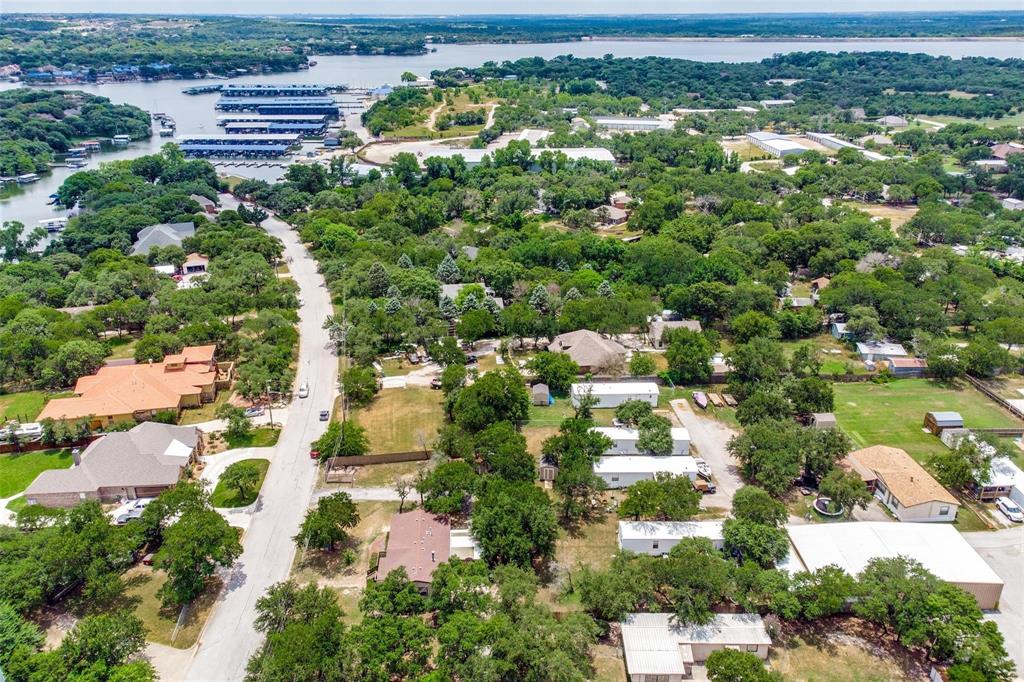 9455 Tranquil Acres Road Fort Worth, TX 76179 - Photo 1 of 20 Aerial perspective showcasing a residential area featuring a winding road, abundant mature trees, and visible water bodies in the background with boat docks