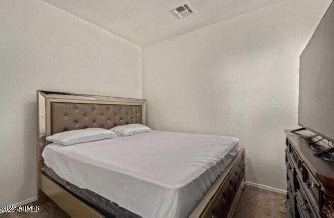 9171 West Berkeley Road Phoenix, AZ 85037 - Photo 18 of 36 a bed sitting in a bedroom next to a window