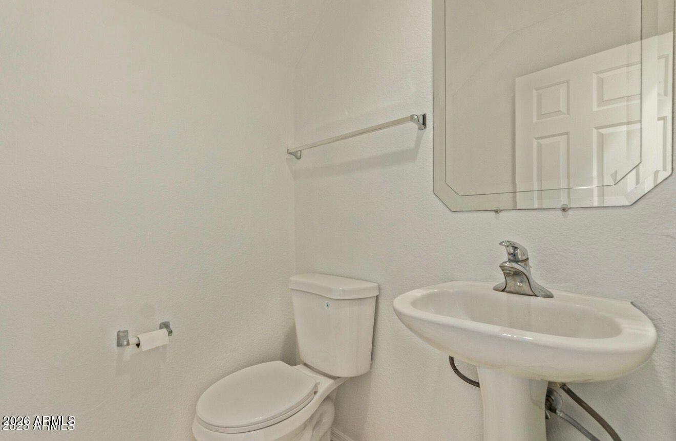 9171 West Berkeley Road Phoenix, AZ 85037 - Photo 22 of 36 a bathroom with a sink a toilet and mirror