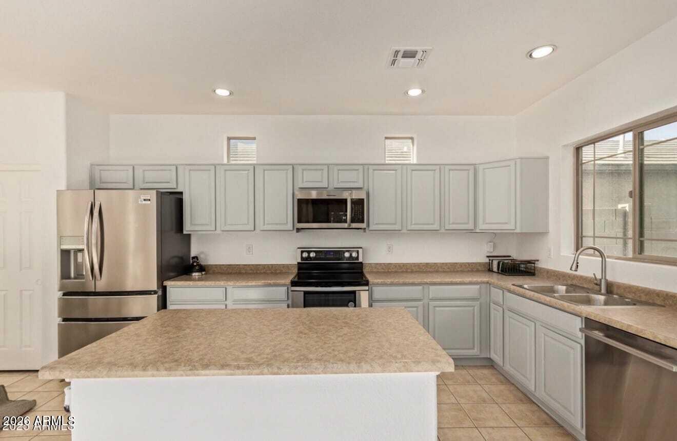 9171 West Berkeley Road Phoenix, AZ 85037 - Photo 5 of 36 a kitchen with a sink a stove and refrigerator