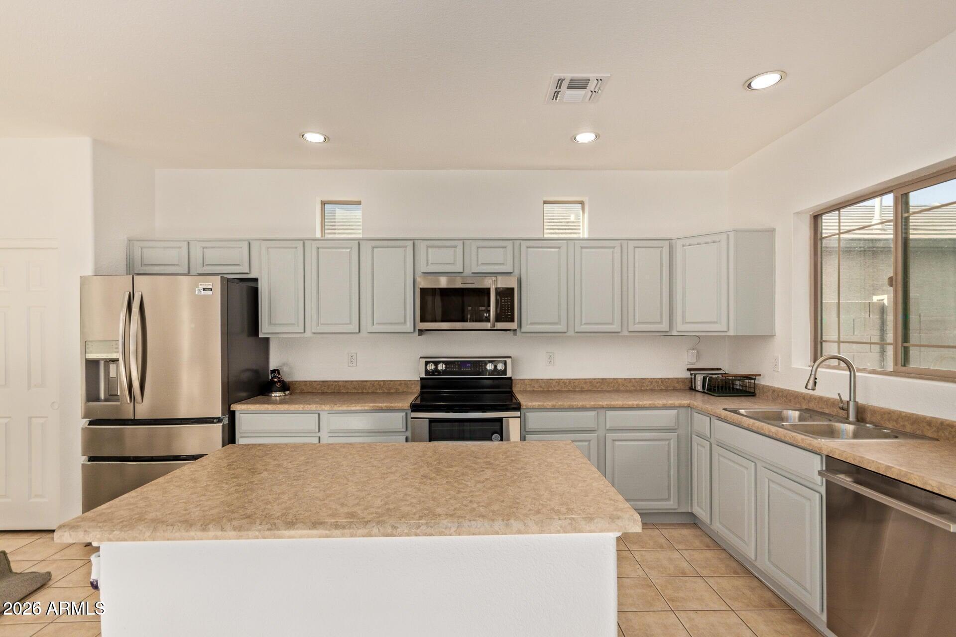 9171 West Berkeley Road Phoenix, AZ 85037 - Photo 8 of 36 a kitchen with a sink a stove and refrigerator