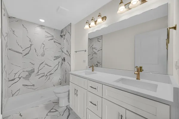 a bathroom with a sink a toilet and shower