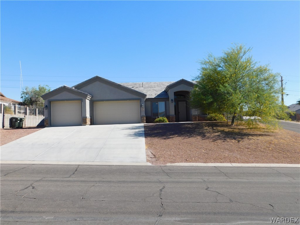 3370 South Ridge Avenue Bullhead City, AZ 86429 - Photo 1 of 56 a front view of a house with a yard and garage
