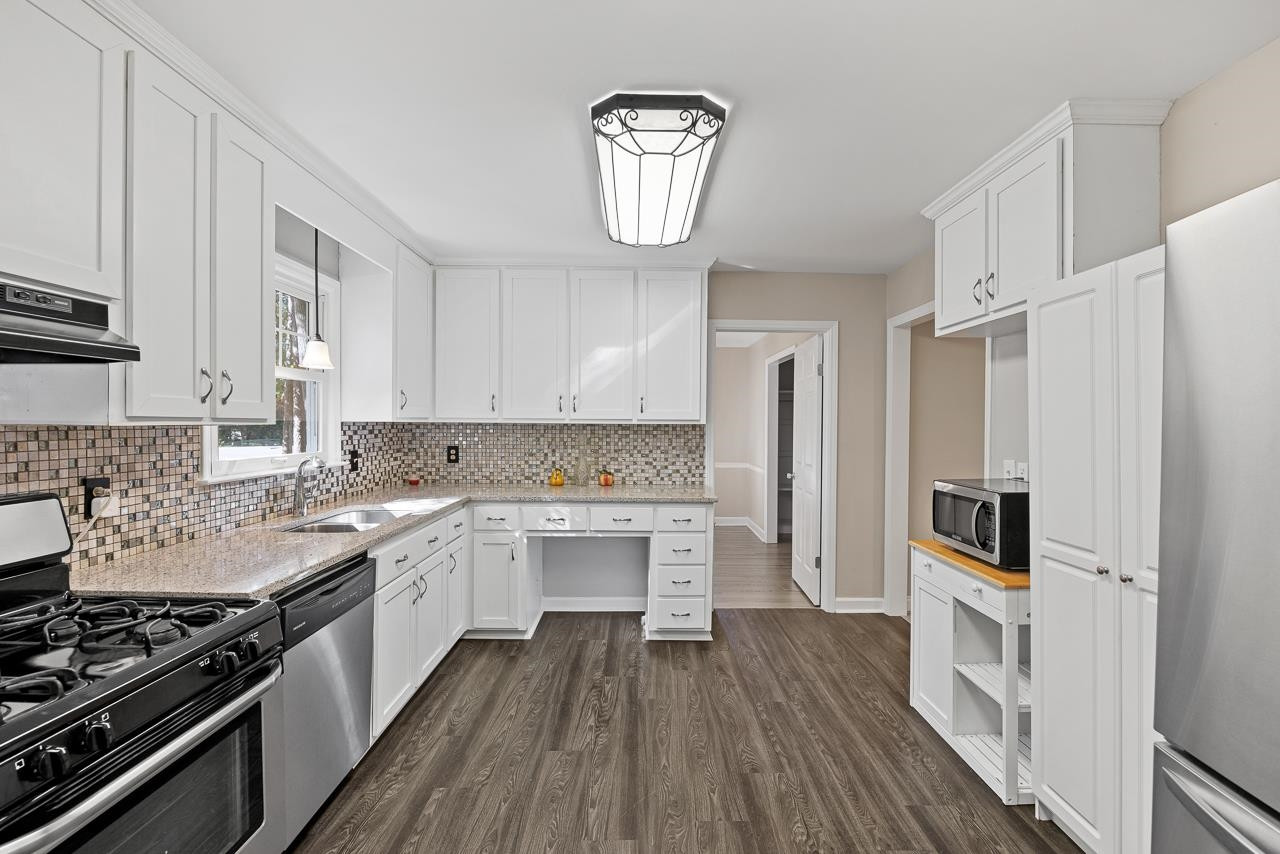 3517 Brecknock Street Durham, NC 27705 - Photo 11 of 38 a kitchen with a sink a counter top space stainless steel appliances and cabinets