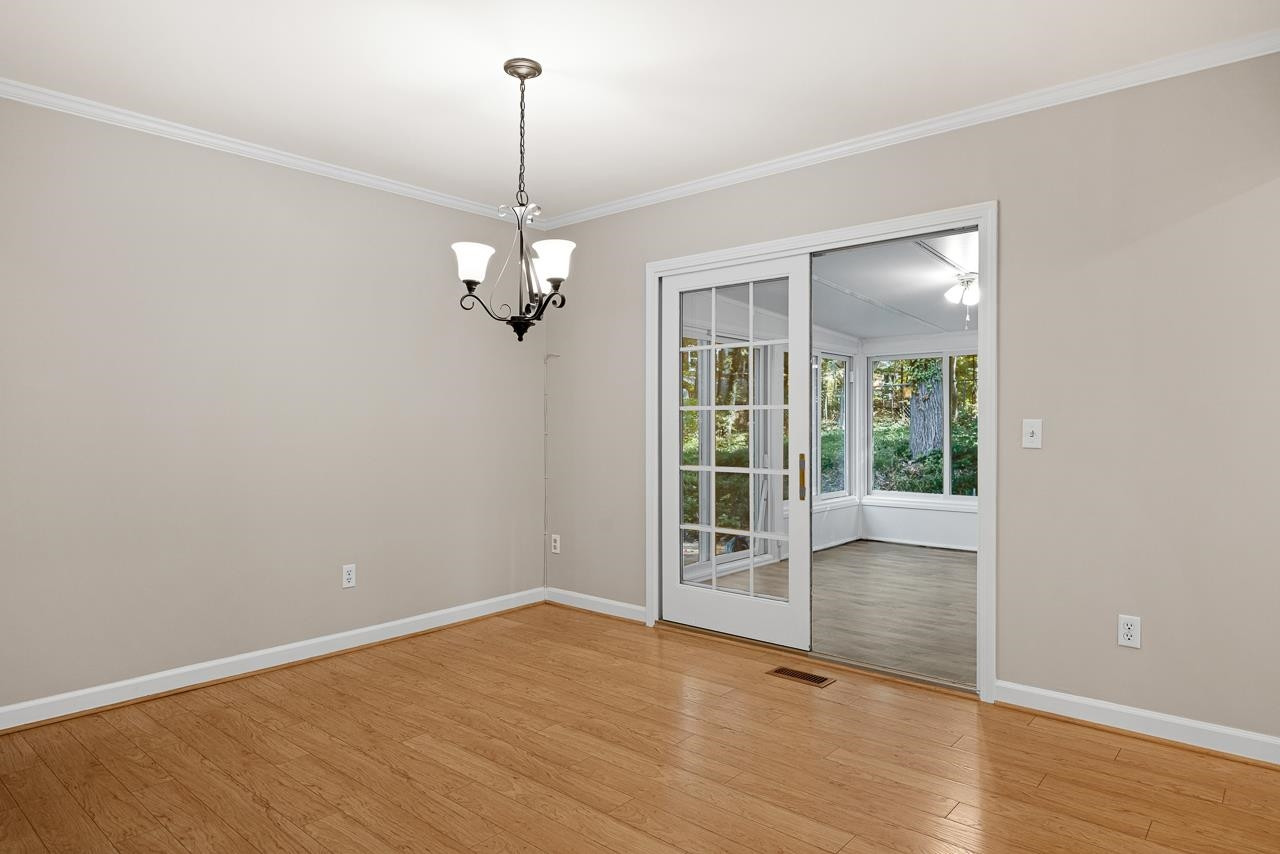 3517 Brecknock Street Durham, NC 27705 - Photo 15 of 38 a view of an empty room with wooden floor and a window