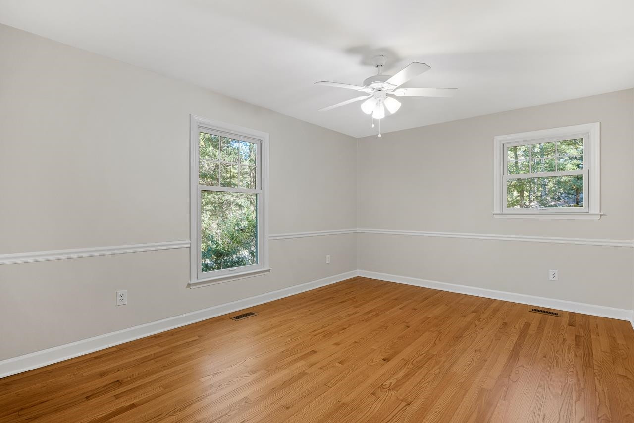 3517 Brecknock Street Durham, NC 27705 - Photo 24 of 38 an empty room with wooden floor windows and fan
