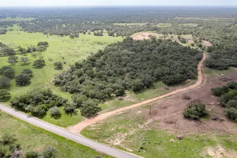 an aerial view of residential houses with outdoor space and trees