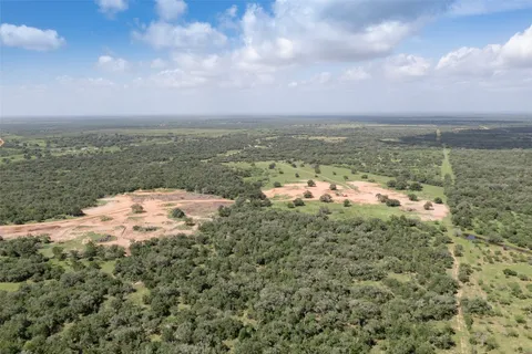an aerial view of residential houses with outdoor space and trees