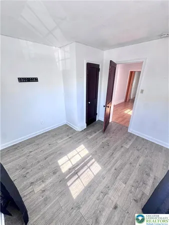 an empty room with wooden floor and closet