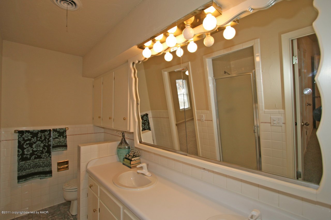 6111 Jameson Road Amarillo, TX 79106 - Photo 13 of 15 a bathroom with a sink a vanity and a mirror