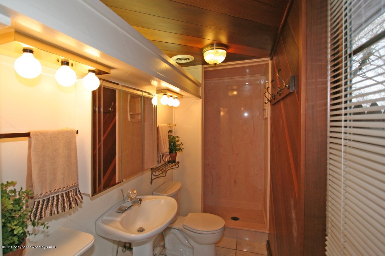 6111 Jameson Road Amarillo, TX 79106 - Photo 14 of 15 a bathroom with a toilet a sink and mirror