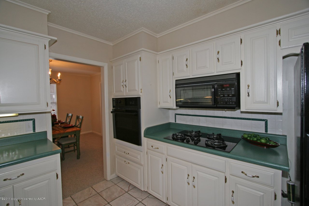 6111 Jameson Road Amarillo, TX 79106 - Photo 3 of 15 a kitchen with stainless steel appliances granite countertop a stove a microwave and a refrigerator