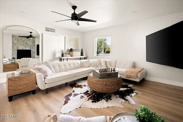 a living room with furniture a flat screen tv and a fireplace