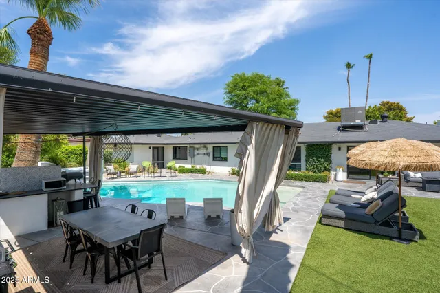 a backyard of a house with table and chairs