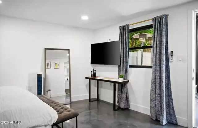 a bedroom with a bed and a flat screen tv