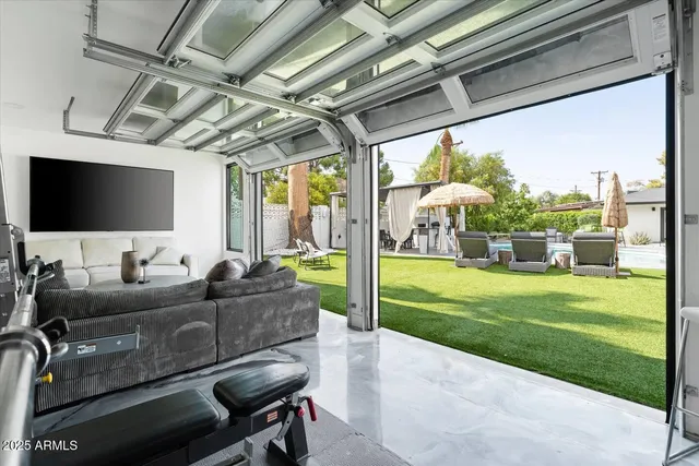 a living room with patio furniture and a flat screen tv