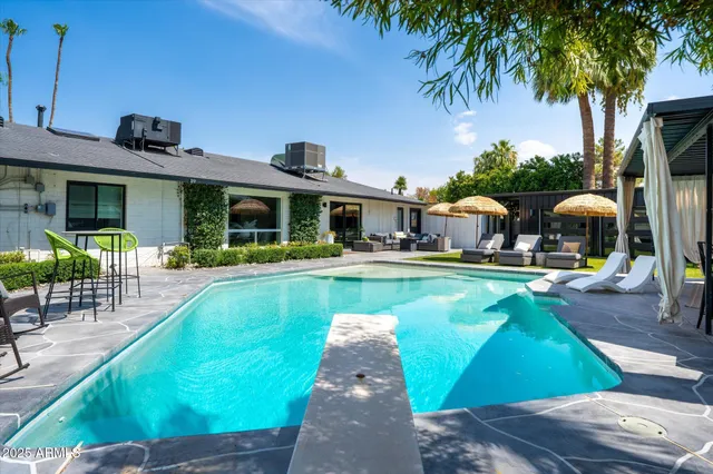a view of a house with swimming pool and sitting area