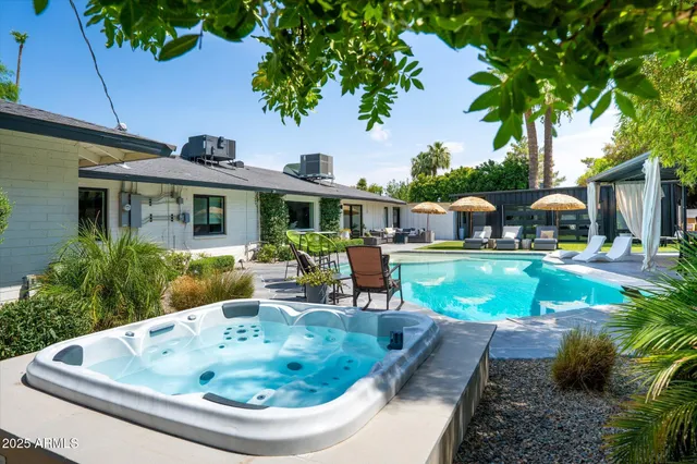 a view of a house with backyard outdoor seating area and swimming pool