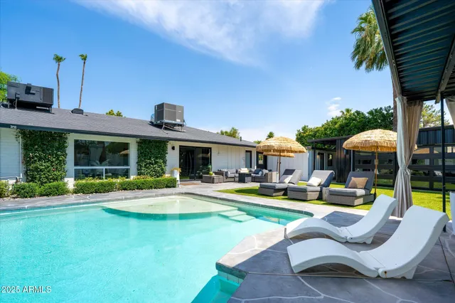 a front view of a house with swimming pool having outdoor seating