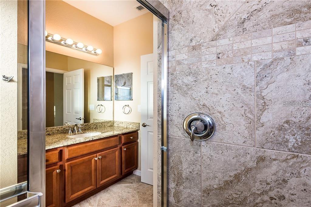 3948 San Rocco Drive, Unit 112 Punta Gorda, FL 33950 - Photo 13 of 18 a bathroom with a granite countertop sink a light fixture and a mirror