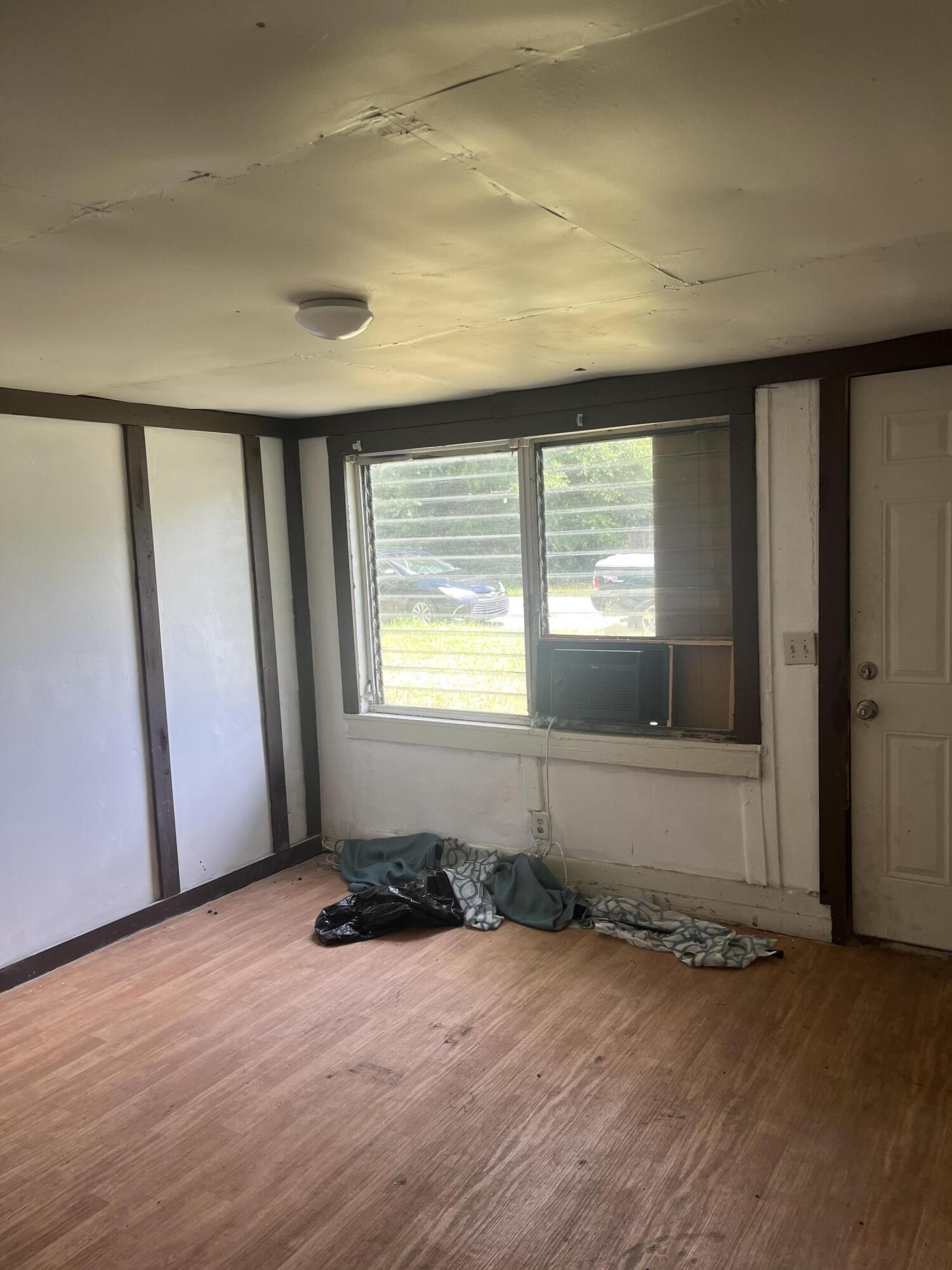 401-409 Brock Avenue Crestview, FL 32539 - Photo 3 of 10 an empty room with wooden floor and windows