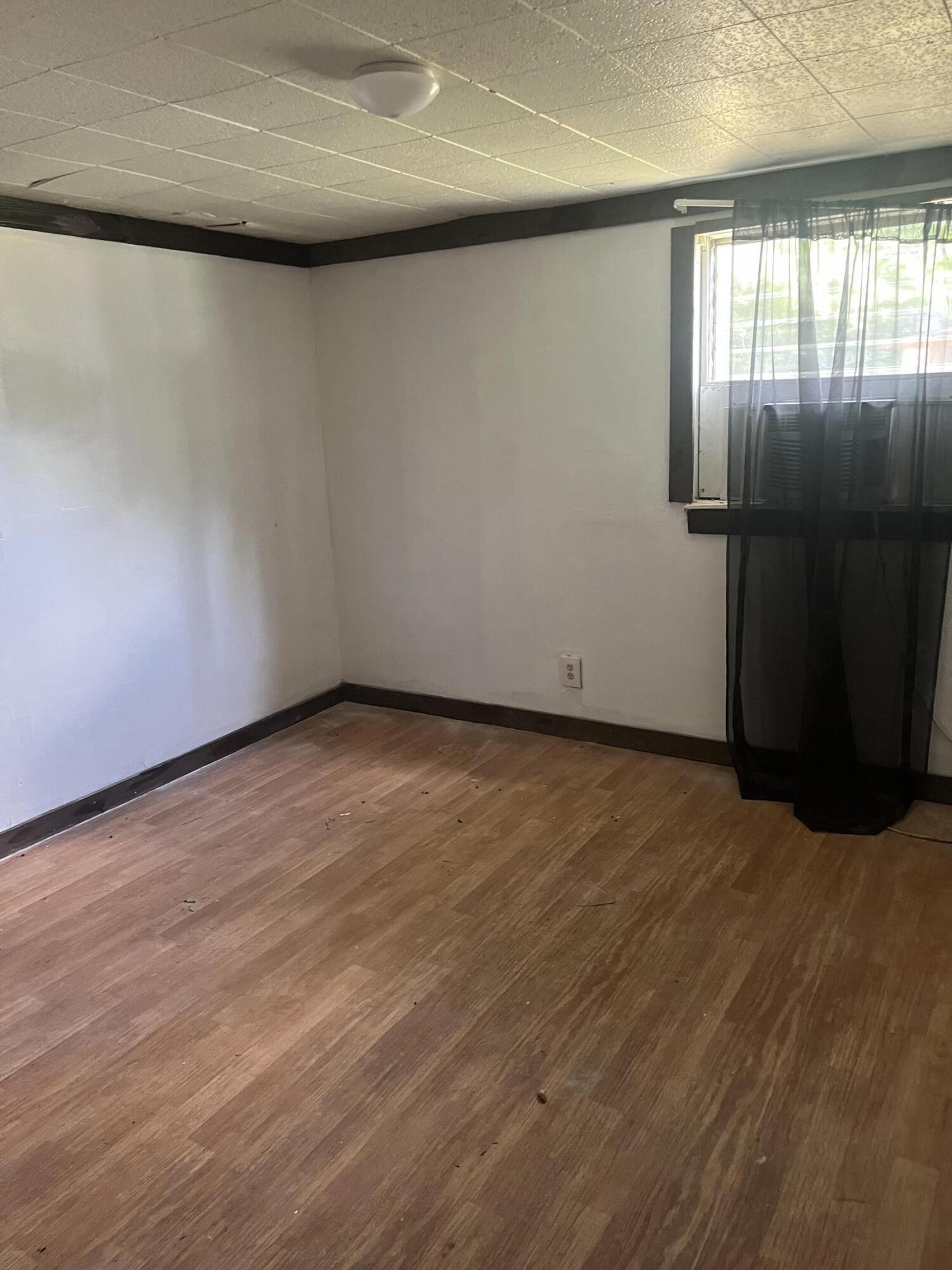 401-409 Brock Avenue Crestview, FL 32539 - Photo 8 of 10 an empty room with wooden floor and windows