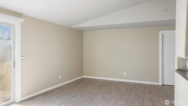 a view of an empty room with closet and a window