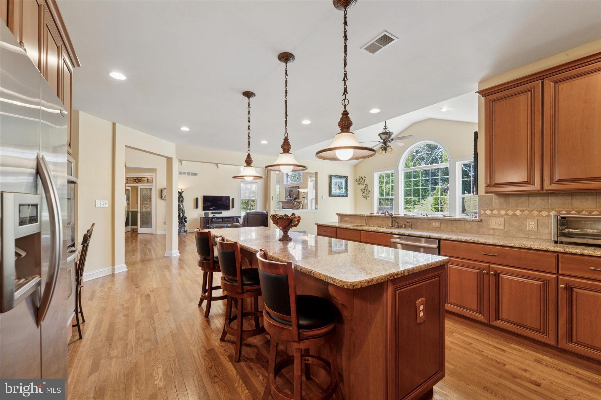 2001 Grenoble Road Coatesville, PA 19320 - Photo 14 of 45 a kitchen with stainless steel appliances granite countertop a stove a sink dishwasher a refrigerator and a dining table with wooden floor