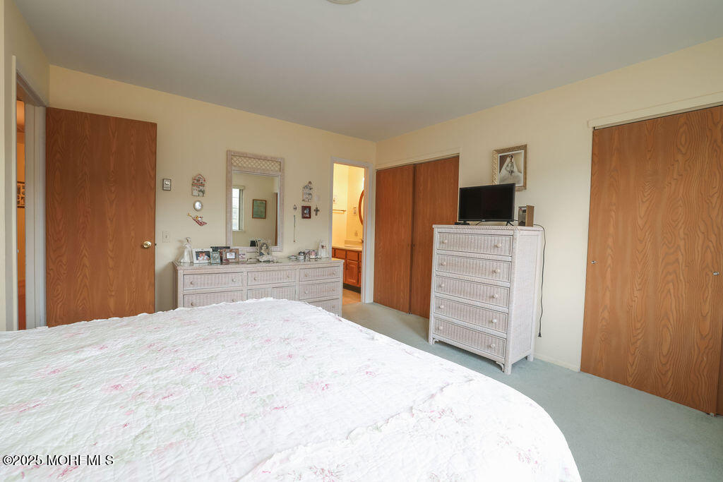 3 B Alpine Road, Unit 63 Whiting, NJ 08759 - Photo 19 of 26 a large bedroom with a bed and a flat screen tv