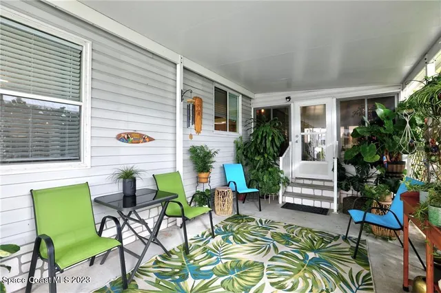a view of a patio with table and chairs and potted plants