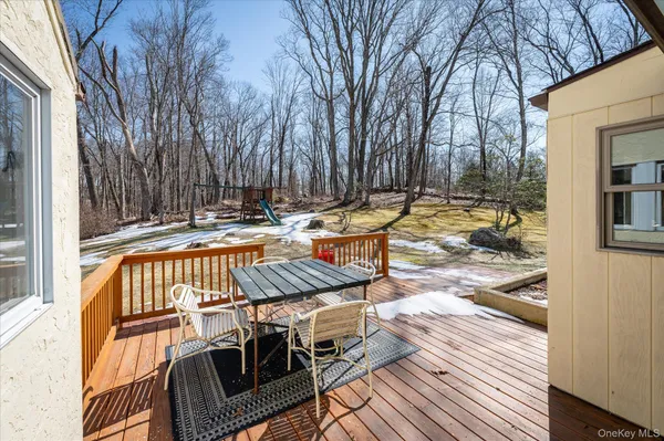 a view of a patio with a table and chairs with wooden floor and fence