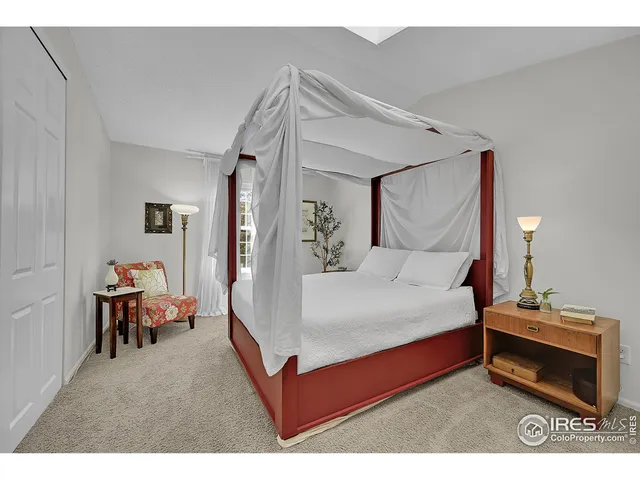 a bedroom with a bed mirror and a window
