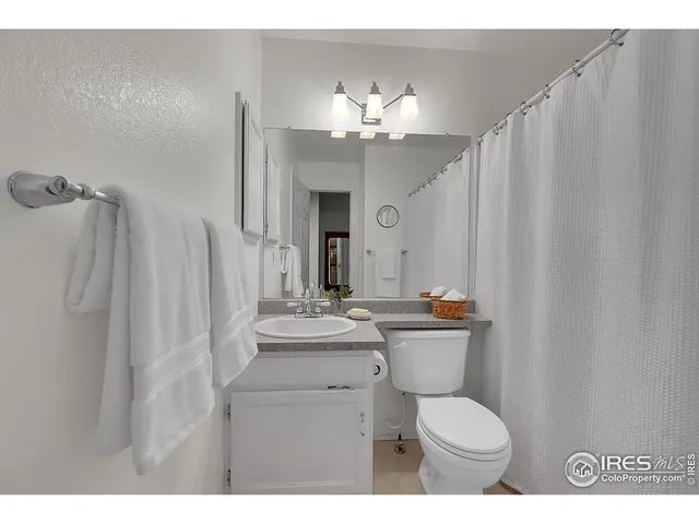a bathroom with a sink vanity mirror and toilet