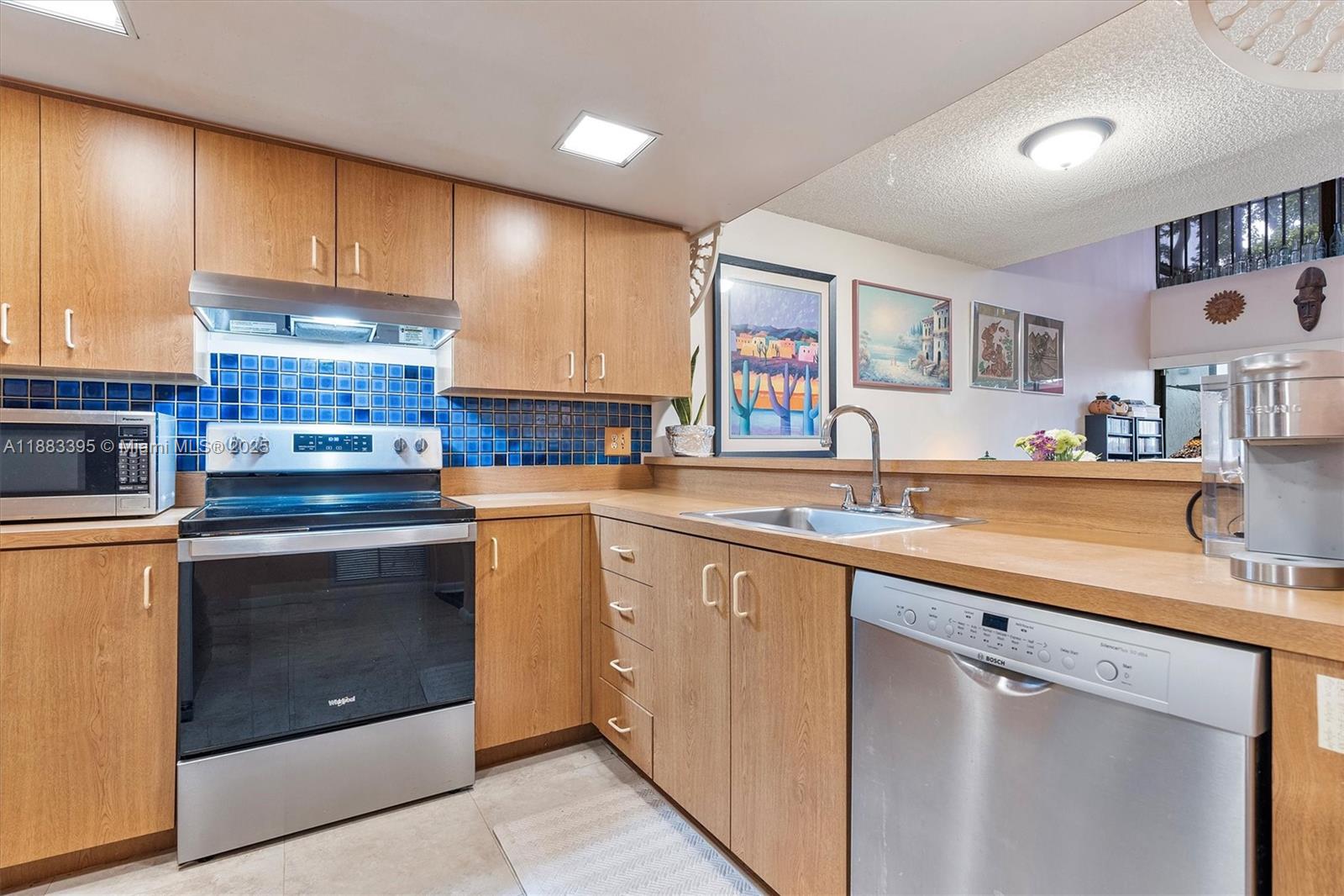 4347 Southwest 70th Terrace Davie, FL 33314 - Photo 4 of 32 a kitchen with stainless steel appliances granite countertop a sink stove and cabinets