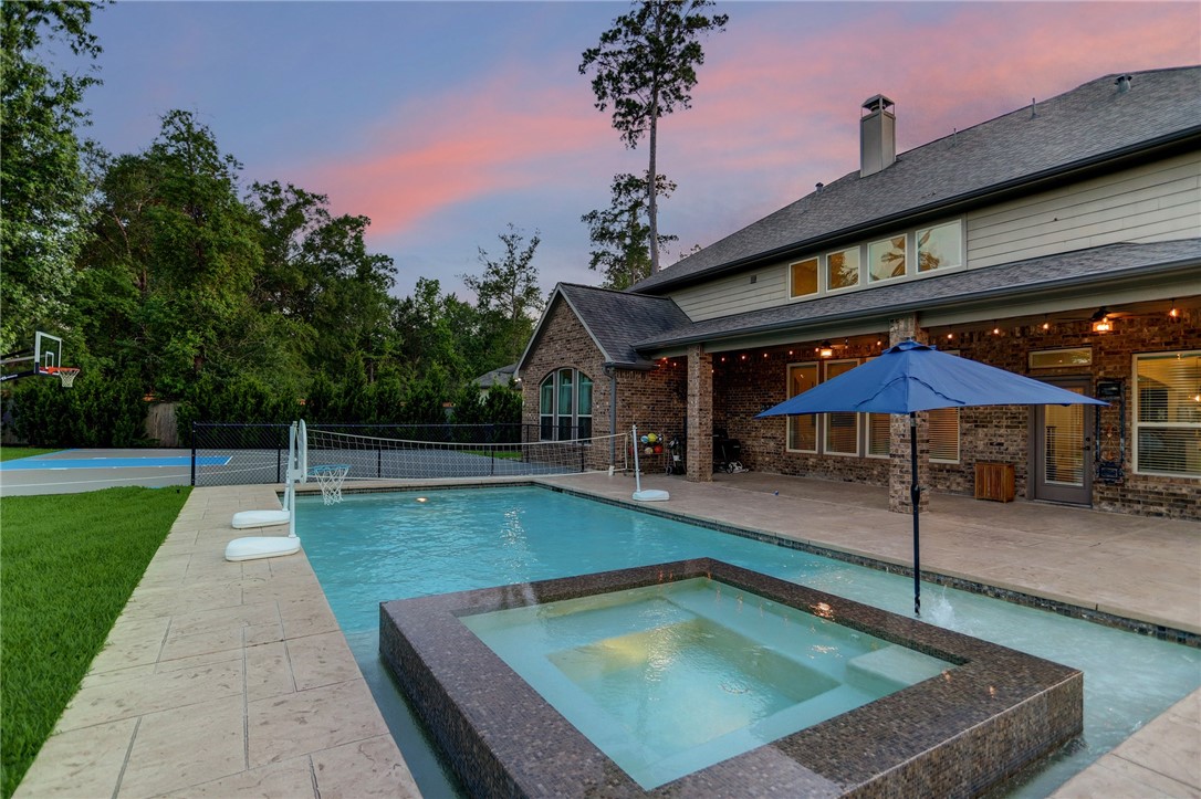 a view of a backyard with a patio and swimming pool