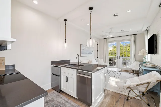 a view of a white house with a swimming pool and sitting area