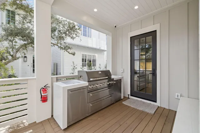 a kitchen that has a lot of white cabinets and stainless steel appliances