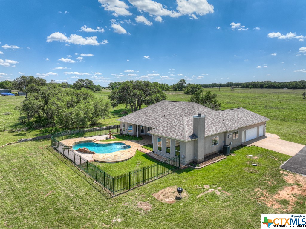 a view of a house with pool and a garden