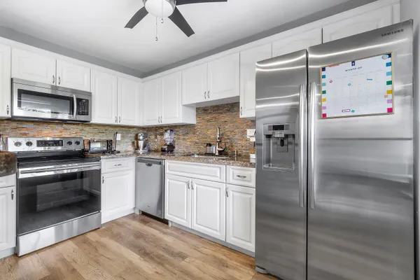a kitchen with stainless steel appliances granite countertop a refrigerator sink and cabinets